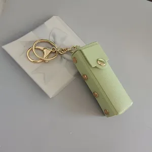 Porte-clés étui à rouge à lèvres en cuir vert clair avec des clous dorés décoratifs