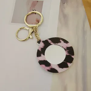 Porte-clés miroir circulaire en cuir avec imprimé léopard rose et noir et fermoir doré chic