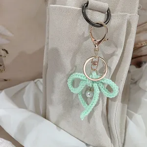 Handmade crochet yarn bow keychain with pearl charm for bag decoration