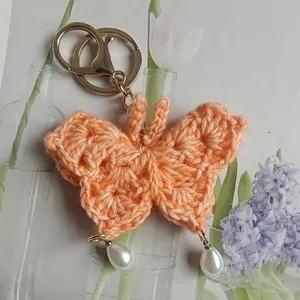 Delicate hand-crocheted peach butterfly keychain with white pearl pendants for bags
