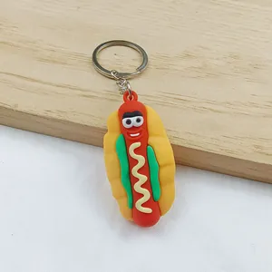 Detail view of a colorful cartoon hot dog keychain with a cute smiling face and sauce