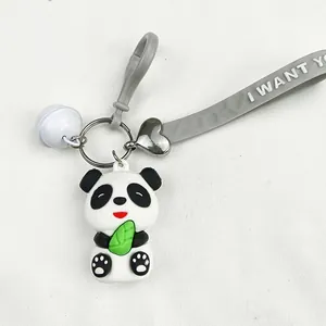 Detail shot of a cute cartoon PVC panda keychain with gray wrist strap and bell