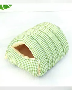 Primer plano de una cama cerrada para mascotas con diseño de cuadros verdes y felpa
