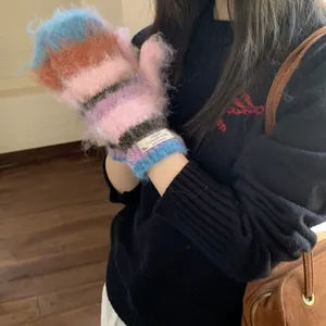 Detailed view of colorful striped fuzzy knit mittens with soft texture for winter warmth
