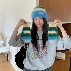 Close-up of model wearing blue gradient mohair beanie and holding matching mittens