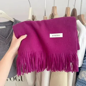 Soft magenta knitted scarf with fringe detail and minimalist tag for winter