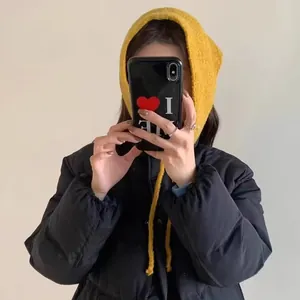 Close-up detail of a vibrant yellow knitted multifunctional hood hat worn in a selfie style.