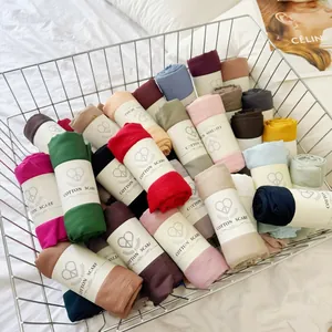 Macro detail showing a variety of colorful crinkled cotton blend scarves in a metal basket