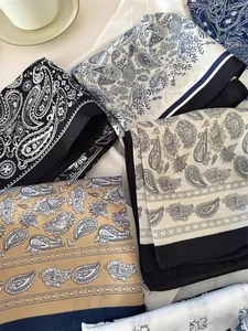 Elegant paisley printed silk scarves in various colors shown in a detailed close-up.