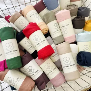 Variety of colorful crinkled cotton blend scarves displayed in a metal basket.
