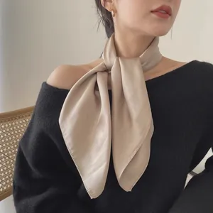 Élégant foulard en soie couleur champagne porté comme un accessoire de cou stylé