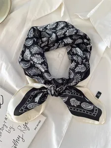 Close-up of black and white paisley silk neckerchief tied on a white shirt collar