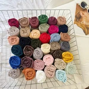 Various colors of wrinkled cotton blend scarves neatly arranged in a silver wire basket