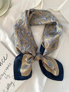 Detailed view of paisley pattern silk scarf elegantly tied on a white shirt background