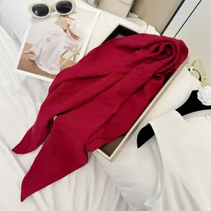 Macro view of a deep red textured scarf draped over a gift box