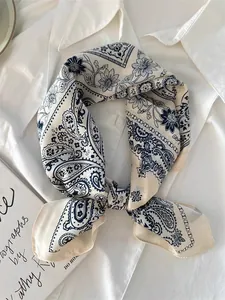 Close-up of elegant paisley pattern silk scarf tied on a white shirt