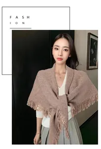 Elegante chal triangular de punto marrón con detalle de borlas en una modelo mujer