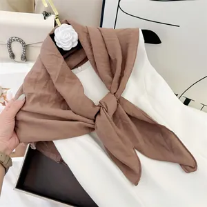 Detail of soft brown cotton-feel wrinkled square scarf styled on a white dress