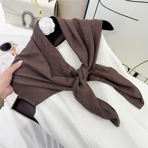 Close-up of brown crinkle cotton feel square scarf with pleated texture detail