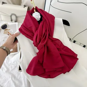 Detail view of pleated texture and straight edge on burgundy cotton blend scarf