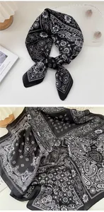 Close-up detail of a vintage black and white paisley pattern silk scarf with floral motifs