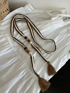 Detailweergave van Boheemse geweven katoenen riem met etnische kralen en kwastjes.