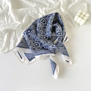 Detailed view of navy blue paisley silk scarf featuring intricate white cashew flower patterns.