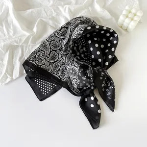 Detailed macro view of the black and white paisley and polka dot silk scarf texture