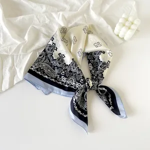 Detailed view of elegant navy blue paisley print silk scarf tied in a decorative knot