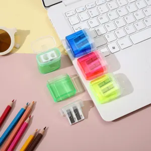 Bunte Mini-Transparent-Doppel-Anspitzer mit Deckeln auf einem Schreibtisch neben Laptop