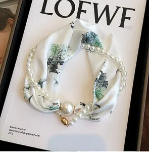 Vue détaillée de l'ensemble collier de perles et foulard en soie avec un fermoir magnétique.