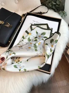 Elegant silk square scarf with white floral print and dark green border on faux fur