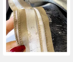 Detailopname van een champagnegoud gestreepte zijden sjaal met fijne stiksels en textuur
