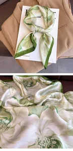 Detailed close-up of green and white floral print on a silky square scarf texture