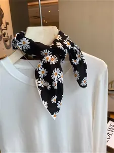 Detail of a black cotton neck scarf with white daisy floral print tied in a knot
