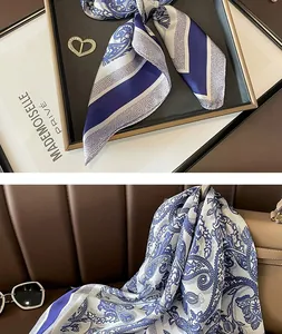 Detailed view of a blue and white paisley pattern silk scarf elegantly draped on a handbag