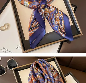 Detailed close-up of a blue paisley printed silk scarf, elegantly tied and neatly folded