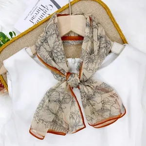Elegant floral printed summer chiffon scarf with contrasting orange rolled hem detail