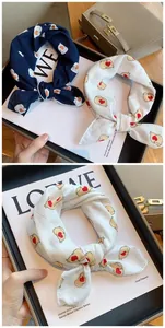 Close-up detail of soft cotton neck scarf featuring cute cartoon seal and red heart pattern
