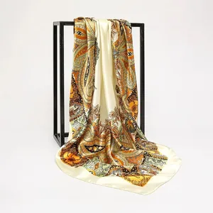 Detail showing the elegant drape and intricate paisley print on a satin square scarf