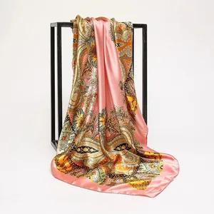 Detail view of a pink satin square scarf with colorful paisley and floral patterns