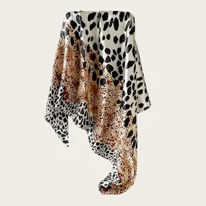 Detail of a silky satin square scarf featuring elegant animal print with a smooth drape.