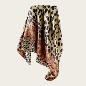 Macro view showing the glossy satin texture and leopard print of the silk square scarf.