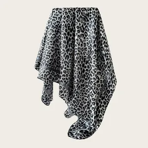 Detail shot of a silky satin square scarf featuring a bold black and white leopard print pattern
