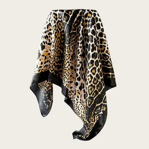 Detailed view of large satin scarf featuring golden leopard print and black borders