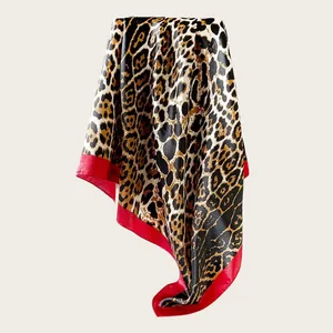 Detailed view of an elegant leopard print satin square scarf with a vibrant red border