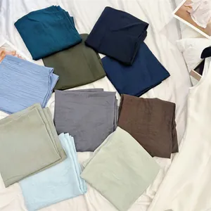 Collection of multi-colored crinkled cotton-feel square scarves with fine pleats.