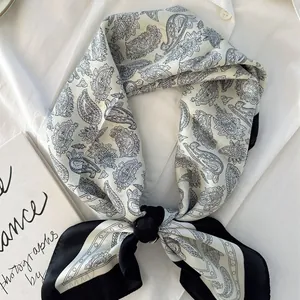 Elegant black and white paisley silk scarf for women, tied over a white professional shirt
