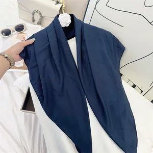 Close-up of navy blue wrinkled square scarf showing soft texture and fine pleats