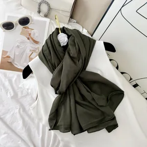Detailed view of olive green wrinkled pleated scarf in a lifestyle setting